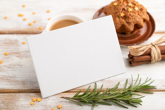 White paper business card mockup with cup of coffee and cake on white wooden background. side view