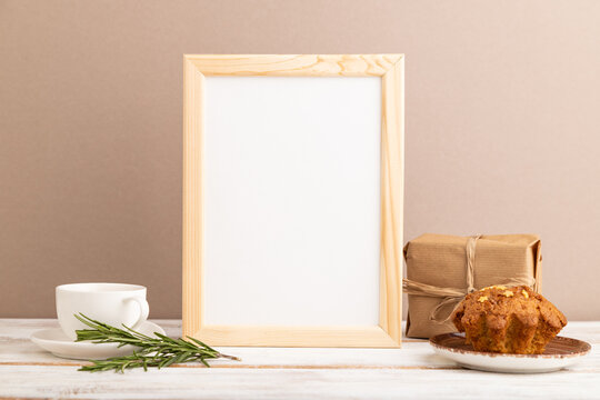White wooden frame mockup with cup of coffee and cake on brown background. side view