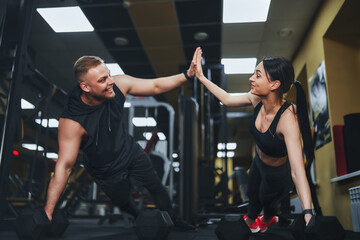 Strong and Beautiful Athletic Fitness Couple in Workout Clothes Doing Push Up Exercises and Giving Each Other a High Five