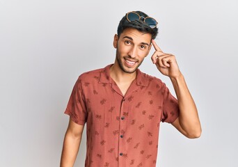 Young handsome man wearing casual summer clothes smiling pointing to head with one finger, great idea or thought, good memory