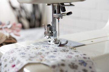 Sewing machine operation from different angles and sewing a flowered fabric. Selective Focus Machine part.