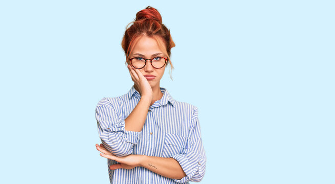 Young redhead woman wearing casual clothes and glasses thinking looking tired and bored with depression problems with crossed arms.