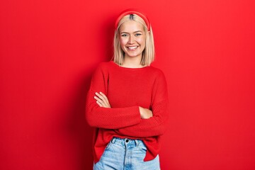 Beautiful blonde woman wearing casual red sweater happy face smiling with crossed arms looking at the camera. positive person. - Powered by Adobe