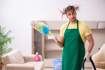 Young male contractor wearing prickly wreath on head cleaning th
