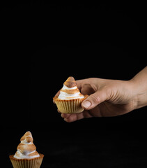 Hand taking traditional french lemon tart on dark backgound