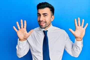 Young hispanic man wearing business clothes showing and pointing up with fingers number ten while smiling confident and happy.