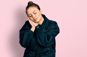 Young hispanic girl wearing sportswear sleeping tired dreaming and posing with hands together while smiling with closed eyes.