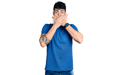 Fototapeta premium Young hispanic man wearing casual t shirt shocked covering mouth with hands for mistake. secret concept.