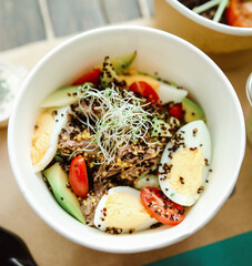 quinoa with meat and vegetables. bowl with eggs, meat and vegetables top view. takeaway food, catering.