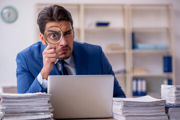 Young businessman employee and too much work in the office