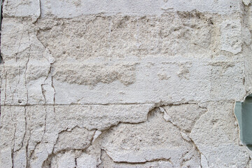 Crumbled plaster on the wall of the house background texture 