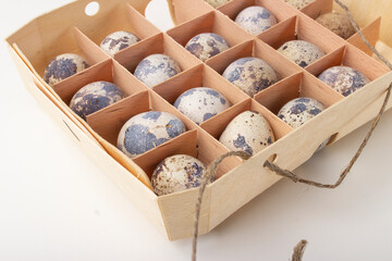 Quail organic eggs in a wooden box with a string 