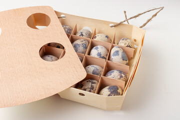 Quail organic eggs in a wooden box with a string 