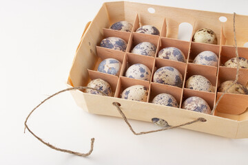 Quail organic eggs in a wooden box with a string 