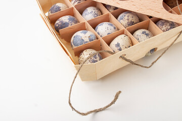 Quail organic eggs in a wooden box with a string 