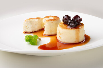 Cheesecakes on a plate with jam and berries on top