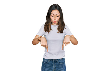 Obraz premium Young beautiful woman wearing casual white t shirt pointing down with fingers showing advertisement, surprised face and open mouth