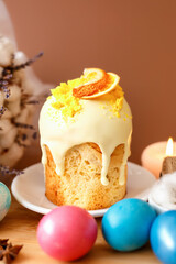 Easter cake and dyed eggs with flowers on brown background. Easter holiday atmosphere card. Easter food for family dinner. Easter composition in rustic style.