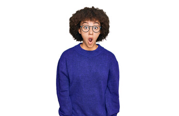 Fototapeta na wymiar Young hispanic girl wearing casual winter sweater and glasses afraid and shocked with surprise expression, fear and excited face.