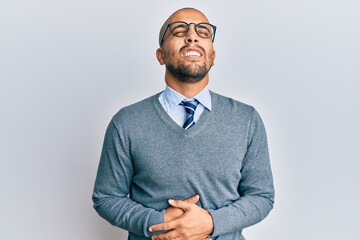 Hispanic adult man wearing glasses and business style with hand on stomach because nausea, painful disease feeling unwell. ache concept.