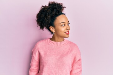 Young african american girl wearing casual clothes looking to side, relax profile pose with natural face and confident smile.