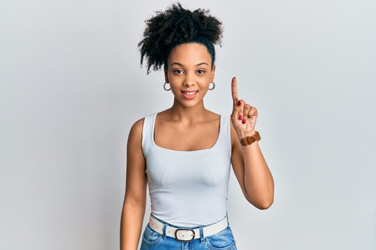 Young african american girl wearing casual style with sleeveless shirt smiling with an idea or question pointing finger up with happy face, number one