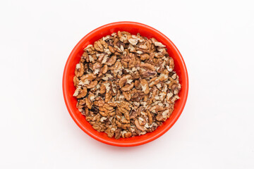 Peeled walnuts in red plastic plate on white background, isolated