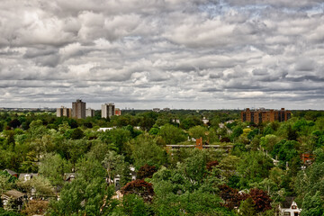 A view of southern Ontario looking east showing the skylines of Toronto and Mississagua on a moody early fall afternoon with trees blowing in the wind