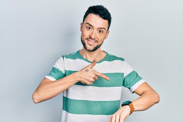 Young hispanic man wearing casual clothes in hurry pointing to watch time, impatience, upset and angry for deadline delay