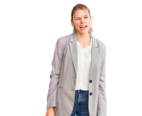 Young beautiful blonde woman wearing elegant jacket winking looking at the camera with sexy...