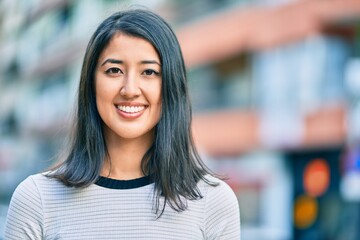 Young hispanic woman smiling happy walking at the city.