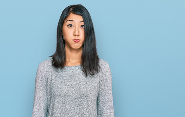 Obraz premium Beautiful asian young woman wearing casual clothes puffing cheeks with funny face. mouth inflated with air, crazy expression.