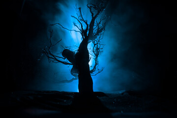 Spooky dark landscape showing silhouettes of trees in the swamp on misty night. Night mysterious...