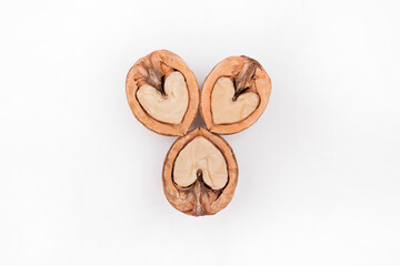 Halves of walnuts in the form of a heart isolated on white background