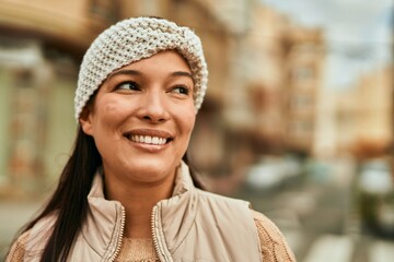 Young latin woman smiling happy standing at the city.