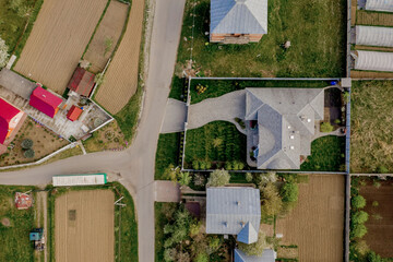 Aerial top view of a house with paved yard with green grass lawn with concrete foundation floor