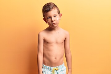 Fototapeta premium Cute blond kid wearing swimwear thinking attitude and sober expression looking self confident