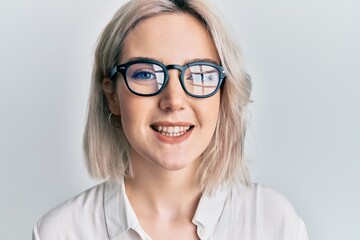Fototapeta na wymiar Young blonde girl wearing casual clothes and glasses looking positive and happy standing and smiling with a confident smile showing teeth