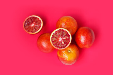 Red oranges, top view. Sliced and whole ripe juicy sicilian blood oranges isolated on pink...