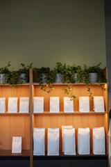 Vertical background image of shelves in coffee shop or tea cafe with mockup craft paper bags, copy space