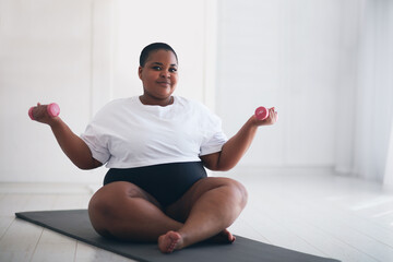 beautiful plus size woman exercising on sport mat at home