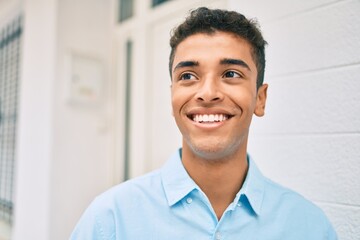 Obraz premium Young latin man smiling happy walking at the city.