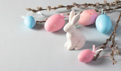 Easter bunny, pussy willow, pink and blue eggs on pastel background. Easter concept. Space for text.