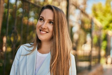 Young blonde businesswoman smiling happy standing at the city.