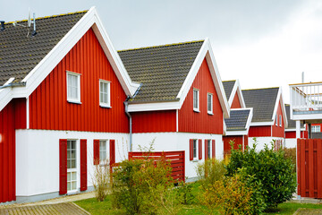 Fototapeta na wymiar Red wooden houses in Sweden. Swedish houses on a street. Vacation in Sweden 