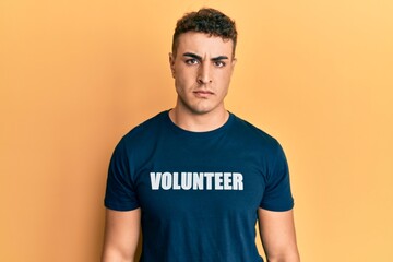Hispanic young man wearing volunteer t shirt skeptic and nervous, frowning upset because of problem. negative person.