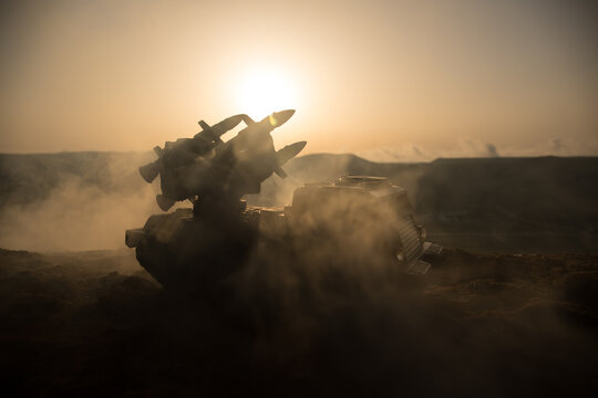 War concept. Battle scene with rocket launcher aimed at gloomy sky at sunset time. Rocket vehicle ready to attacSelective focus