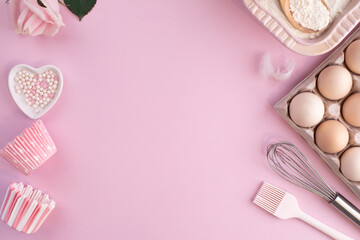 Frame of food ingredients for baking on gently pink pastel background. Cooking flat lay with copy space.