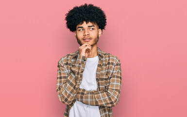 Fototapeta na wymiar Young african american man with afro hair wearing casual clothes with hand on chin thinking about question, pensive expression. smiling with thoughtful face. doubt concept.