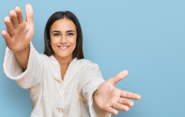 Young brunette woman wearing casual clothes looking at the camera smiling with open arms for hug. cheerful expression embracing happiness.